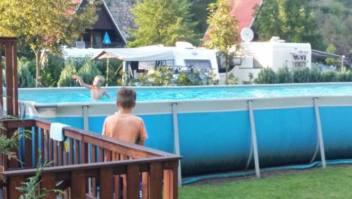 a young boy standing next to a swimming pool at Camping Karolina in Planá