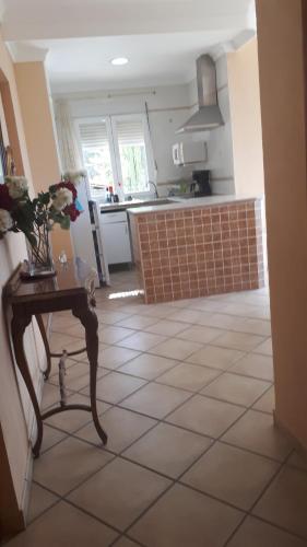 a kitchen with a table with flowers on a tiled floor at Apartamentos CHRISTINA in Benicàssim