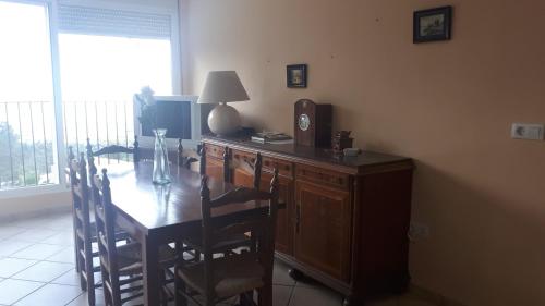 a room with a wooden table and a desk with a lamp at Apartamentos CHRISTINA in Benicàssim