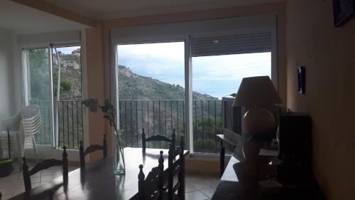 a living room with a balcony with a view of a mountain at Apartamentos CHRISTINA in Benicàssim