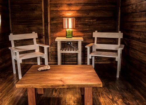 a room with two chairs and a table and a lamp at Las Pitras Lodge in Epuyén