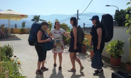 a group of women with backpacks talking to each other at Hotel Bebej Tradicional in Gjirokastër