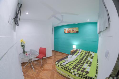 a room with a bed and a table with a chair at Hotel San Carlos in Acapulco