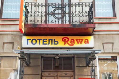 a sign on the front of a building with a balcony at Rawa in Rava-Rusʼka