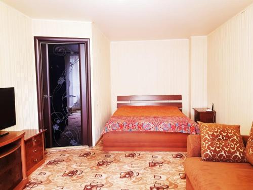 モスクワにあるАпартаменты Стремянный переулокのベッドルーム(ベッド1台、ソファ、テレビ付)