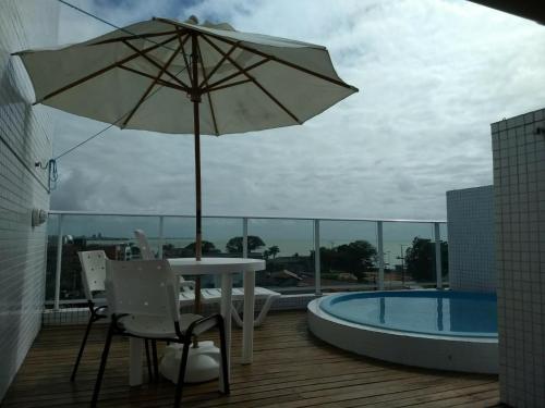 - une terrasse avec une table et un parasol à côté de la piscine dans l'établissement Israel Flat Tambaú Apt 418 - Cobertura Duplex com Piscina Privativa, à João Pessoa