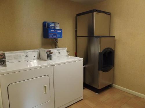 a laundry room with a washer and a refrigerator at Windjammer Lodge in Ogdensburg