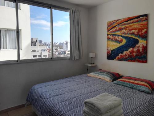 a bedroom with a bed and a painting on the wall at Plaza in Buenos Aires
