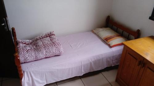a small bed with two pillows on top of it at Pousada Arco Íris in Tabapira