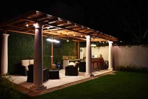 a pergola with chairs and a table in a yard at night at 11B Jaco Sol Quadplex in Jacó