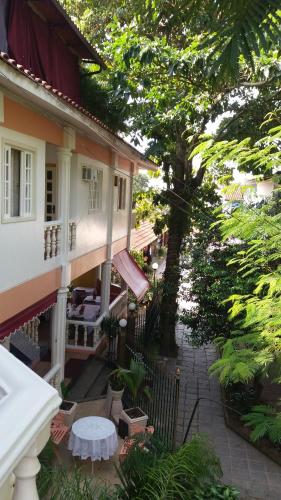 a balcony of a house with a table and a tree at Pousada Casablanca in Abraão