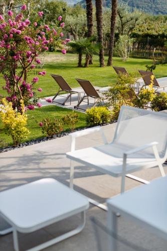 a row of white chairs in a park with flowers at ALEA - Garda Lake Suite in Arco