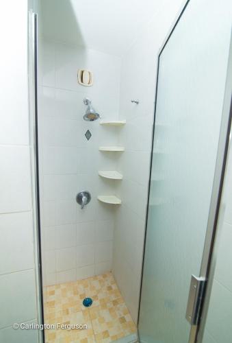 a bathroom with a shower with a glass door at Turtle Beach Towers in Ocho Rios