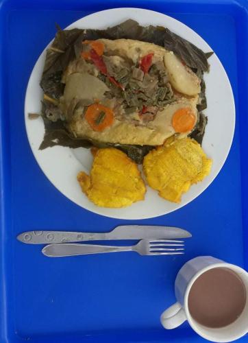 a plate of food on a blue tray with a fork and knife at Gran Muelle Hotel in San Bernardo del Viento