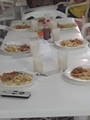a table with plates of food and glasses of milk at Gran Muelle Hotel in San Bernardo del Viento