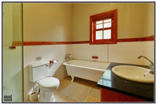 La salle de bains est pourvue d'une baignoire, de toilettes et d'un lavabo. dans l'établissement Peace Cottage, à Port Shepstone