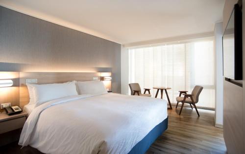 a hotel room with a bed and a table and chairs at Pullman Vina del Mar San Martin in Viña del Mar