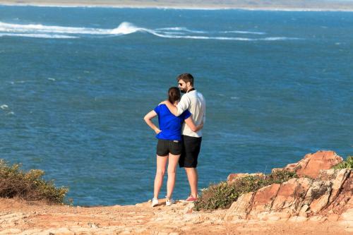 a man and a woman standing on a cliff overlooking the ocean at Bundala Flamingo Cotteges in Hambantota