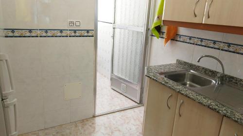 a small kitchen with a sink and a shower at Viviendas Moreno Mar Menor in Santiago de la Ribera