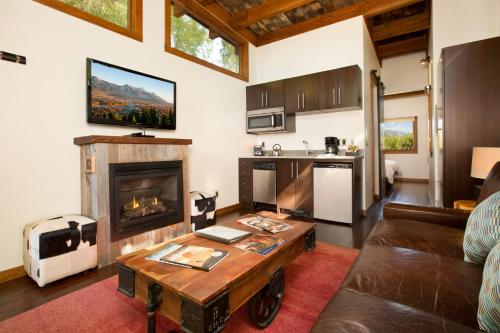 Fireside Resort في ويلسون: غرفة معيشة مع أريكة ومدفأة