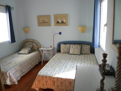 a bedroom with two beds and a table at Casa na praia e golfe in Vale do Lobo