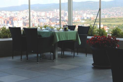 a dining table and chairs with a view of a city at Hotel International Prishtina & Spa in Pristina