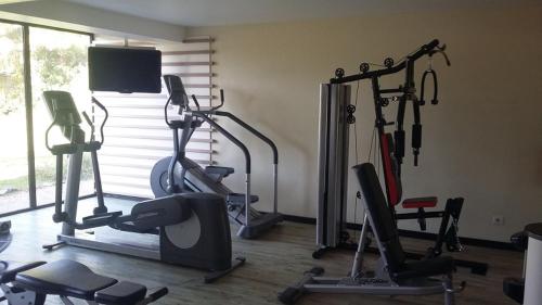 a gym with several exercise bikes and a flat screen tv at Grand Hotel Montabo in Cayenne