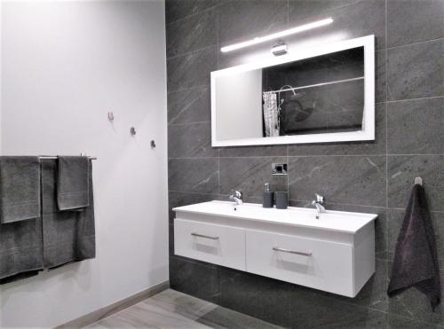 bagno con lavandino bianco e specchio di Apartamentos Ainara a Santa Cruz de Tenerife