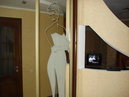 a statue of a woman in a white dress on a wall at Апартаменти по Сковороди in Khmelʼnytsʼkyy
