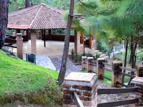 a pavilion with a table and benches in a park at Bosque La Luna in Mazamitla