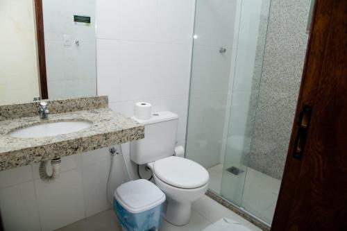 a bathroom with a toilet and a sink and a shower at Pousada Porto Prime in São João da Barra
