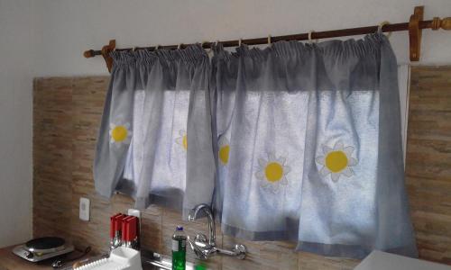 a kitchen curtain with yellow flowers on it at Hosteling Las Margaritas in Minas