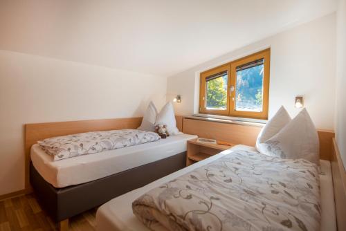 Tempat tidur dalam kamar di KENDLGUT Appartements am BioBauernhof inklusive unbegrenztem Eintritt in die Alpentherme