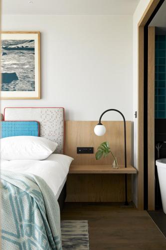 a bedroom with a bed and a desk with a lamp at PURO Kraków Kazimierz in Kraków