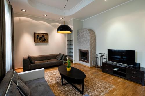 a living room with a couch a table and a tv at Old Riga Jekaba street Apartment in Rīga