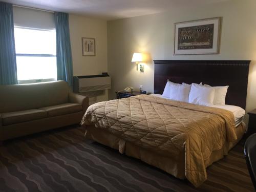 a hotel room with a bed and a couch at Budget Inn - Farmington in Farmington