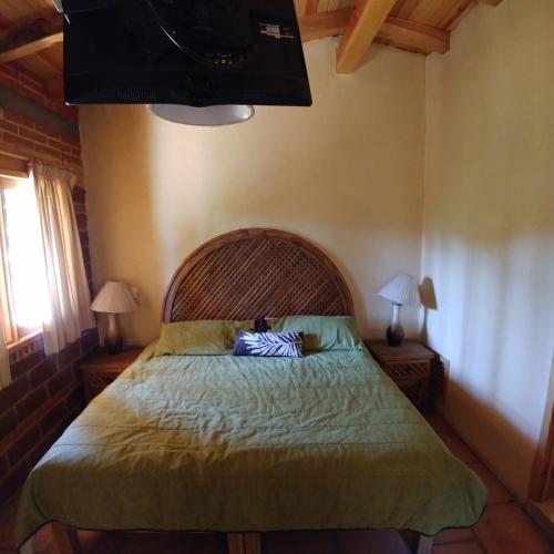 a bedroom with a bed and two lamps and a television at Bosque La Luna in Mazamitla