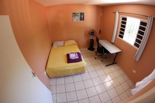 - une chambre avec un lit, un bureau et une fenêtre dans l'établissement Casa com varanda próximo da Natureza, à Foz do Iguaçu