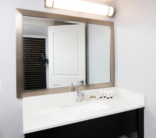 a bathroom with a sink and a large mirror at Red Lion Inn & Suites Tucson Downtown in Tucson