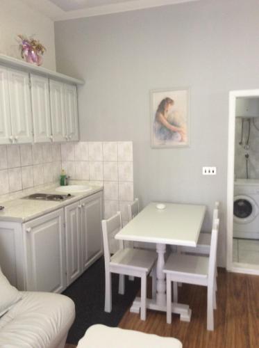 cocina con mesa blanca, sillas y fregadero en Apartman Andrea, BN centar, en Bijeljina