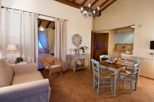 a kitchen and living room with a table and chairs at Agriturismo Poggio Di Maremma in Pescia Romana