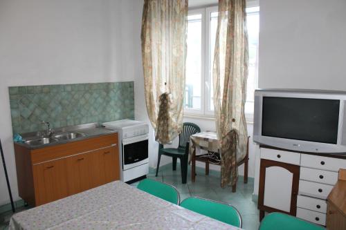 - une cuisine avec évier et une télévision dans la chambre dans l'établissement Appartamenti Di Iorio, à Ischia