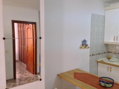 cocina con nevera y puerta a una habitación en Apartamentos Brisamar a 50 metros de la playa, en Valle Gran Rey