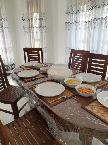 a table with plates and bowls of food on it at Air Port 5 Minutes Super Clean Upul in Negombo