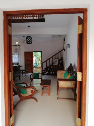 an open door into a living room with furniture at Air Port 5 Minutes Super Clean Upul in Negombo