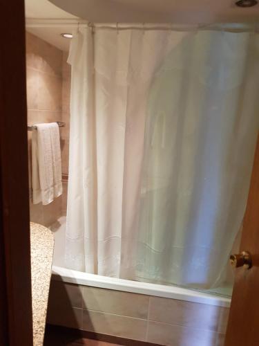 a bathroom with a shower with a white shower curtain at Departamento Céntrico in Rosario
