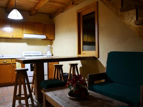 a kitchen with a counter and a table and chairs at Bosque La Luna in Mazamitla