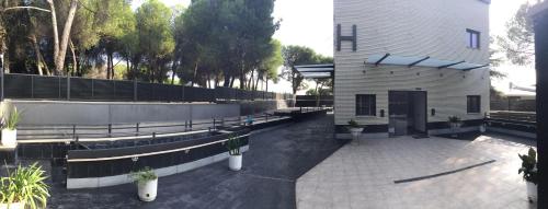 a building with a lot of benches in front of it at H La Cabaña in Pozuelo de Alarcón