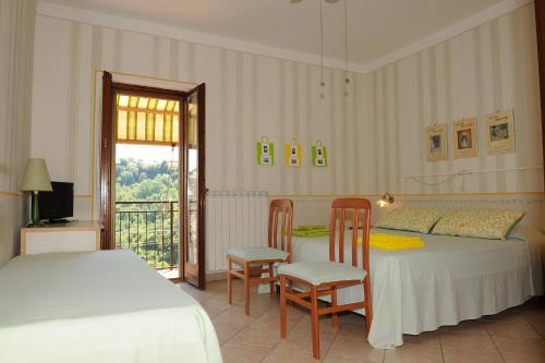 1 Schlafzimmer mit einem Bett, 2 Stühlen und einem Tisch in der Unterkunft La Casa Del Sole in Bomarzo