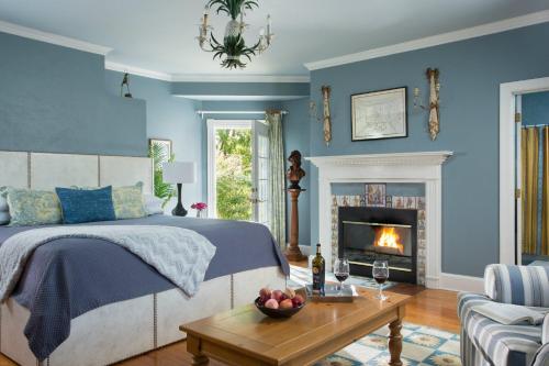 a bedroom with blue walls and a bed and a fireplace at L'Auberge Provencale Inn & Restaurant in Boyce